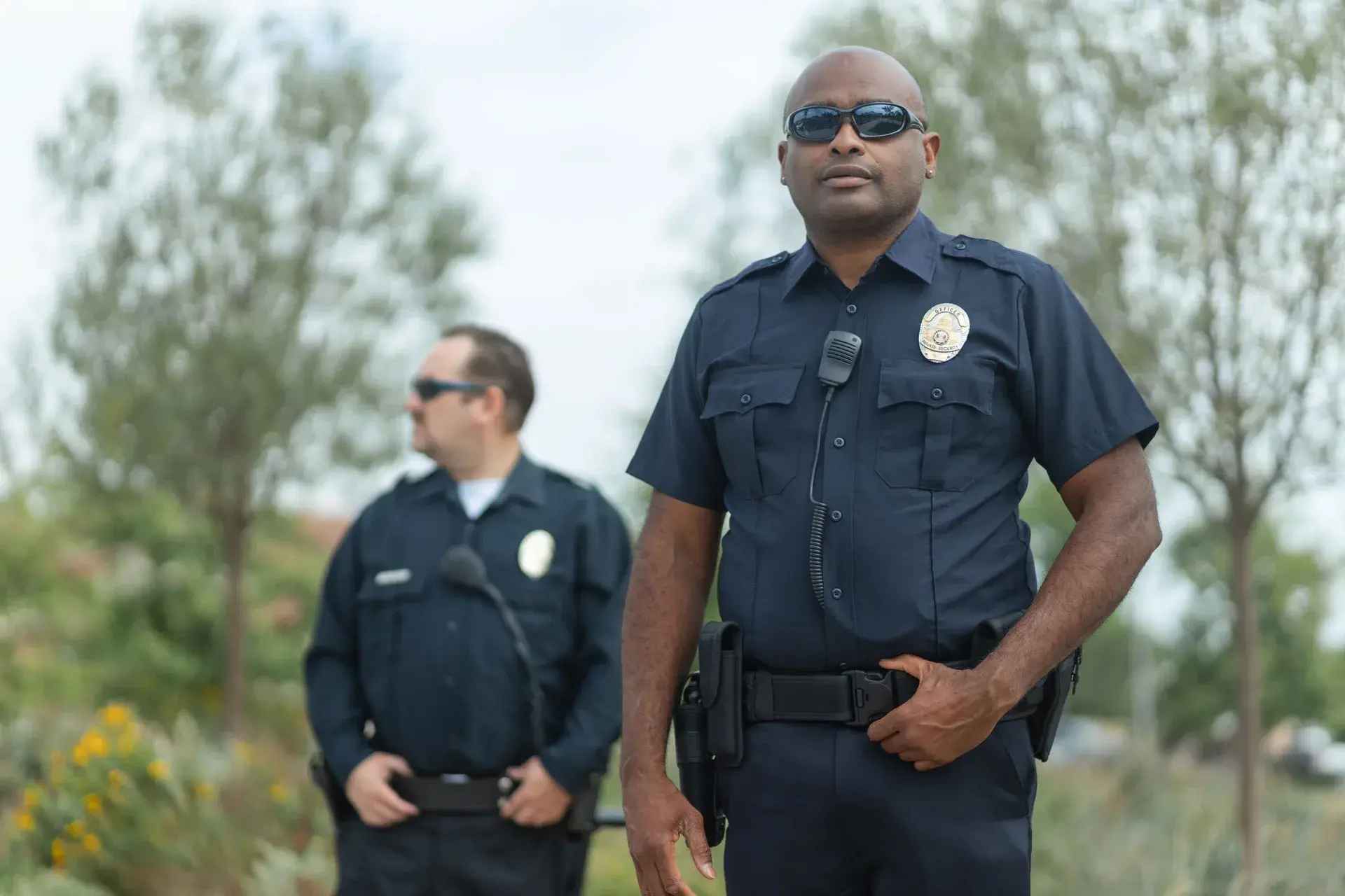Two uniformed officers standing together outdoors