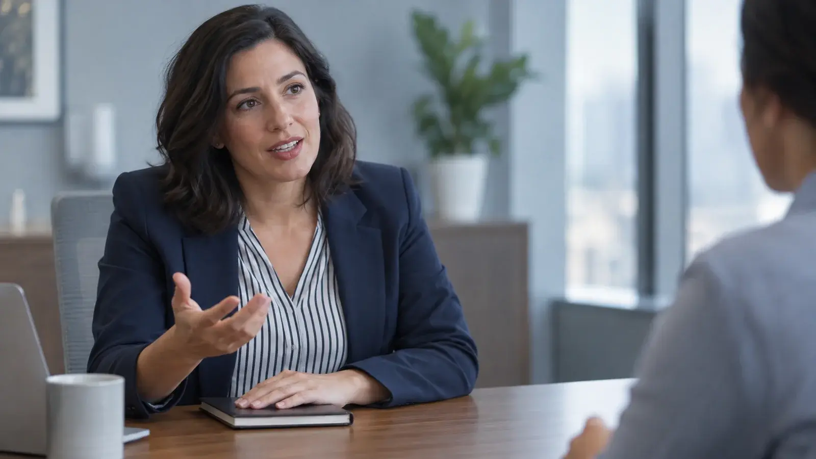 A manager discusses a sales performance review at a meeting table.
